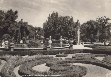 Vintage black and white photo of a formal garden with fountains and sculptures.