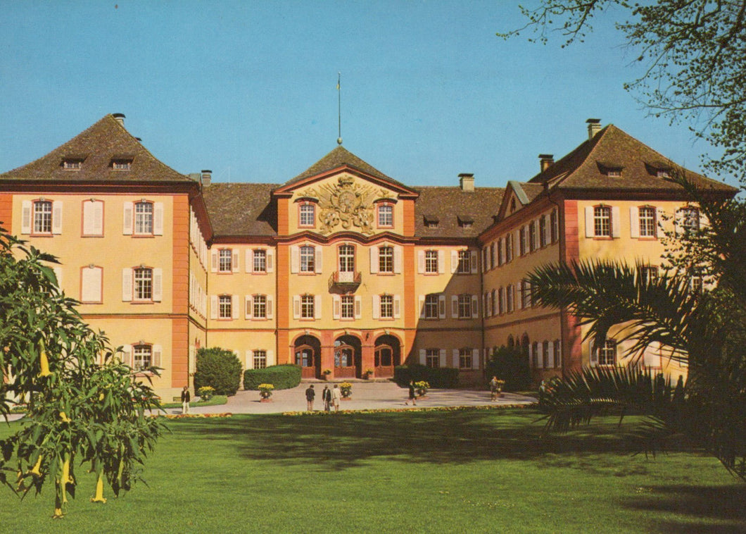 Large building with a garden in front on a clear day