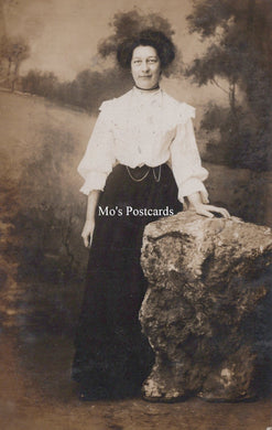 Vintage photograph of a woman posing on a rock with 'Mo's Postcards' text overlay.
