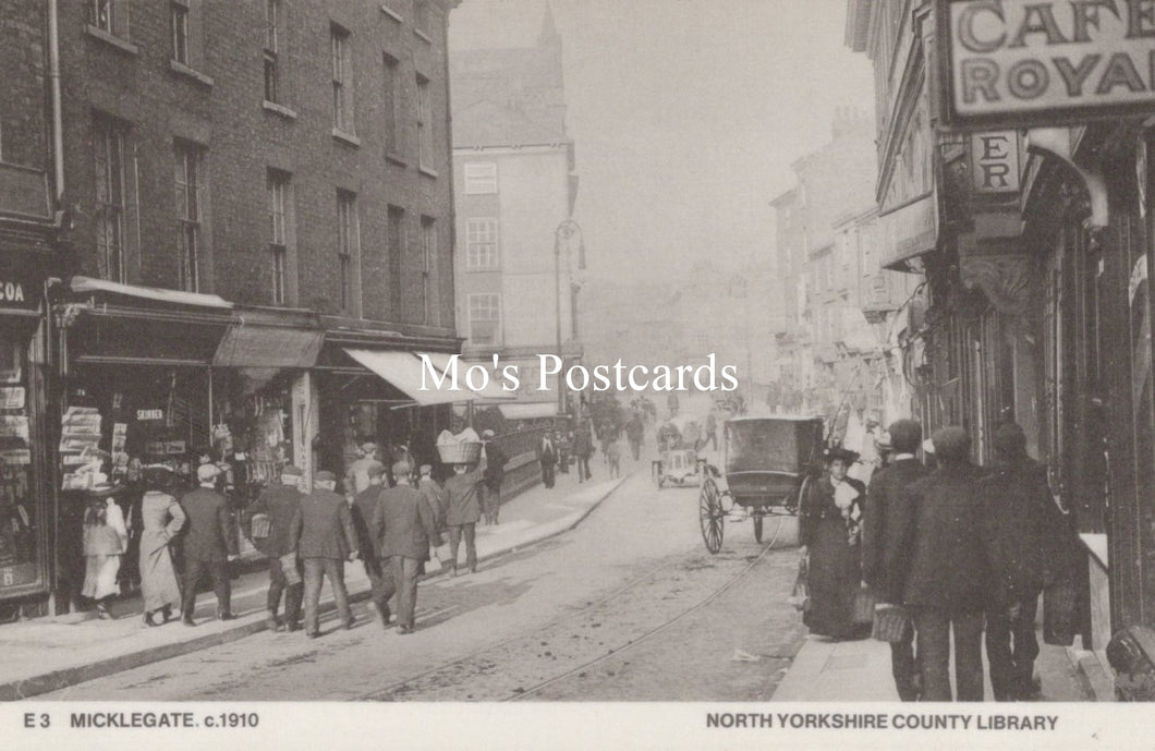 Vintage black and white photo of a street scene with people and shops 