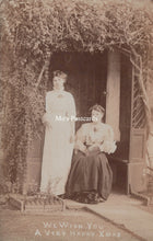 Load image into Gallery viewer, Vintage photograph of two women standing under a tree with a door in the background, labeled &#39;Mo&#39;s Postcards&#39;.
