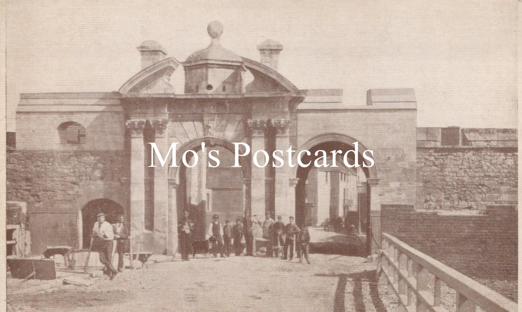 Vintage black and white photo of a stone building with people gathered outside 