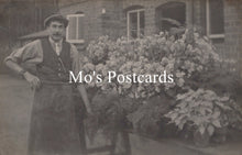 Load image into Gallery viewer, Vintage photo of a man standing in front of a building with plants 
