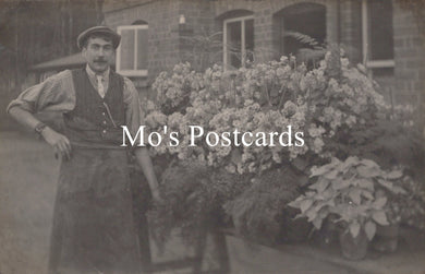 Vintage photo of a man standing in front of a building with plants 