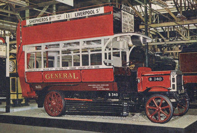 Vintage red double-decker bus model on display in a warehouse setting