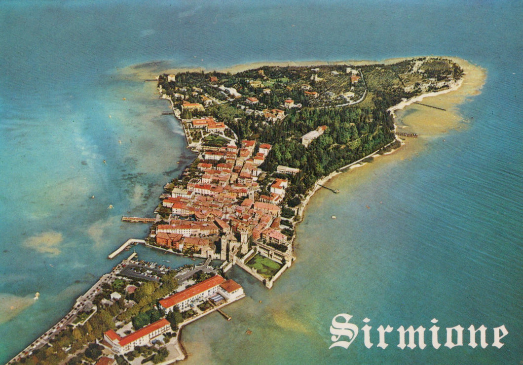 Aerial view of Sirmione on an island with clear blue water.
