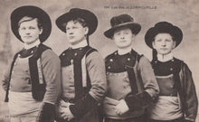 Load image into Gallery viewer, Four men in uniform with hats, standing side by side on a vintage photo.
