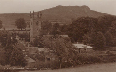 Vintage sepia-toned photograph of a village with a church and surrounding landscape.