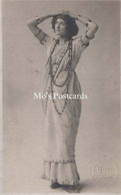 Vintage black and white photograph of a woman in an elegant dress with jewelry.