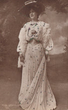 Load image into Gallery viewer, Vintage photograph of a woman in an elaborate dress with floral details against a cloudy sky.

