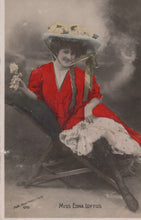 Load image into Gallery viewer, Woman in a red dress and large hat sitting on a bench, with &#39;Miss Eona Loftus&#39; text.
