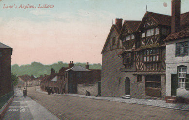 Vintage postcard of a street scene with buildings, including a half-timbered house, in a town setting.