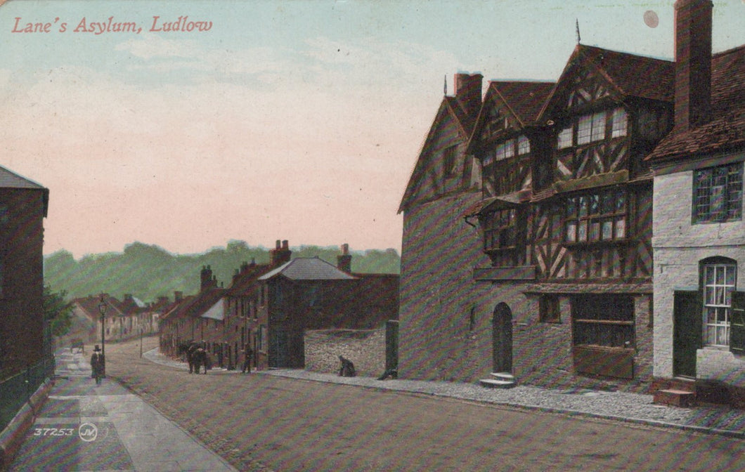 Vintage postcard of a street scene with buildings, including a half-timbered house, in a town setting.