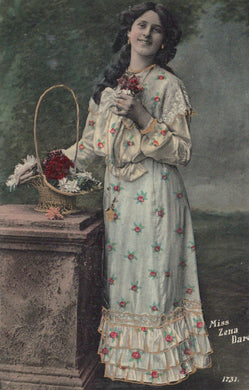 Woman in a floral dress holding flowers and a basket, with a dark background