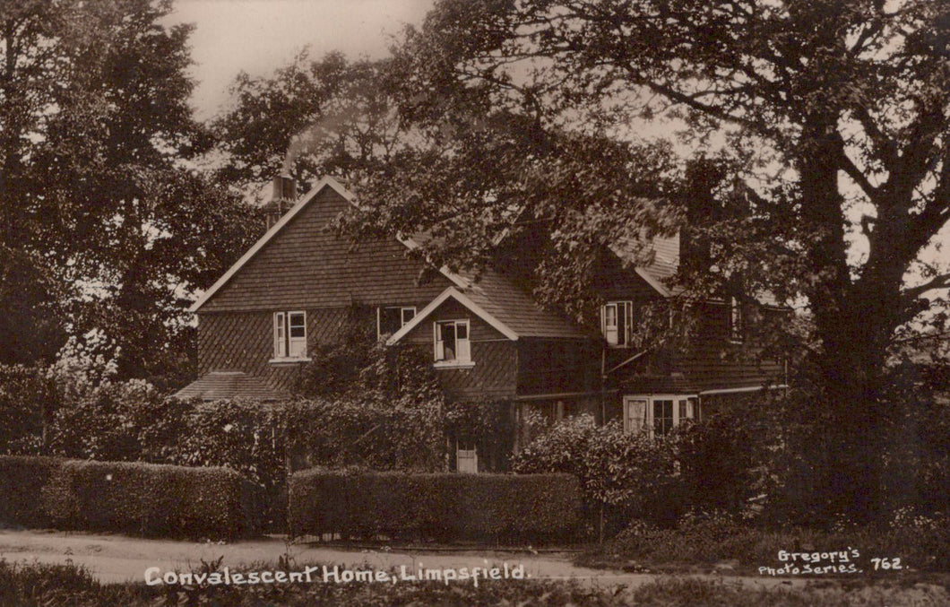Vintage black and white photograph of a house with trees and garden