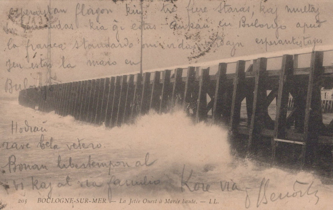 Vintage postcard of a stormy sea with a pier, featuring handwritten text.