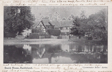 Vintage black and white photograph of a house with a pond and trees