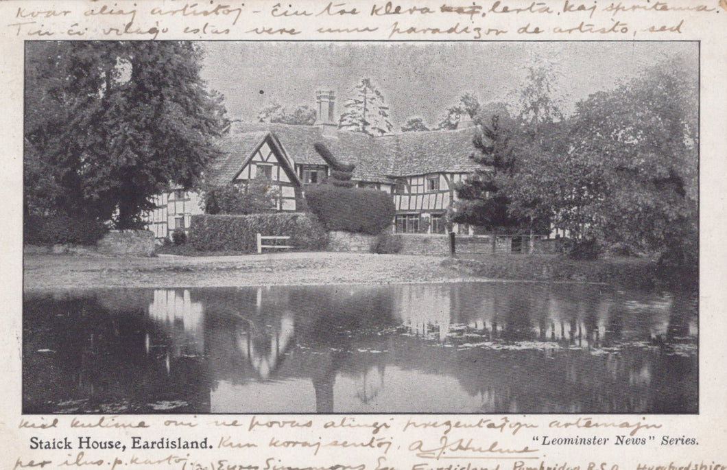 Vintage black and white photograph of a house with a pond and trees