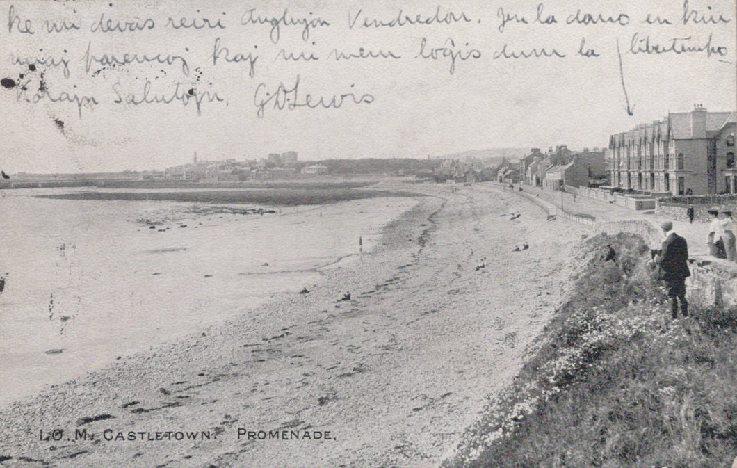 Black and white photograph of a promenade with buildings and people in the distance.