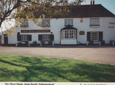 Pub named 'Three Kings Jacks Booth' with white walls and black roof, surrounded by green grass and trees.