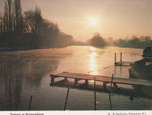 Load image into Gallery viewer, Sunset over a lake with a dock and trees in the background
