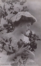 Load image into Gallery viewer, Vintage photograph of a woman holding flowers with a decorative hat.
