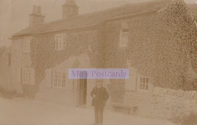 Vintage sepia-toned photograph of a man standing in front of a stone building with 'Mox's Postcards' text overlay.
