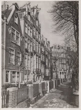 Load image into Gallery viewer, Narrow street with row houses on either side in a black and white photograph
