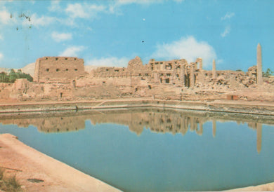 Ruins of an ancient city with a large pool in the foreground