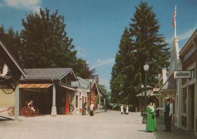 Vintage-style street scene with people and buildings under a clear blue sky.